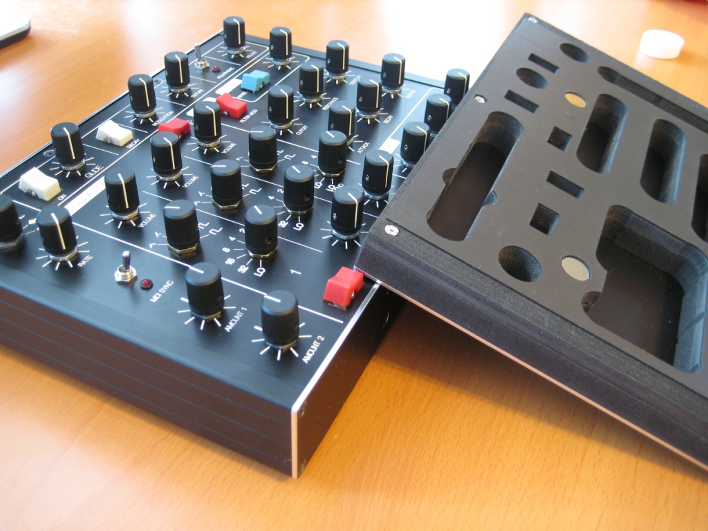 The cover flipped to show its foam underside cut as an exact negative of the panel's knobs and controls
